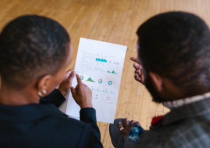 Two people reviewing a printed financial analytics report together