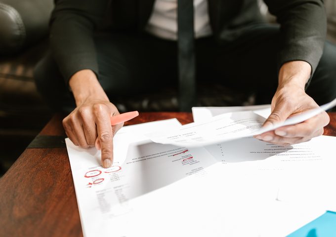 Hands reviewing a financial statement with figures circled in red