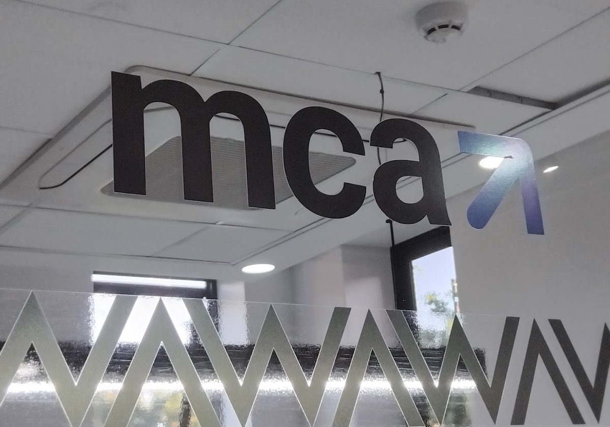 Close-up of the MCA Consulting Limited sign mounted on the office ceiling